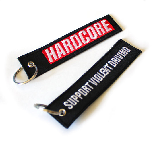 Two keychains with text 'HARDCORE' and 'SUPPORT VIOLENT DRIVING' on a white background.
