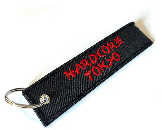 Black keychain with red text 'Hardcore Tokyo' on a white background