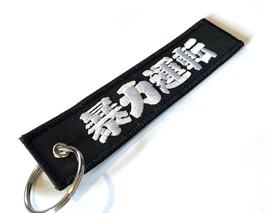Black keychain with silver text on a white background