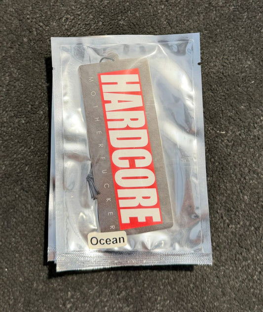 Clear plastic packaging with 'Hardcore' label on a dark surface. Hardcore Tokyo Logo Air Freshener with an Ocean Flavour